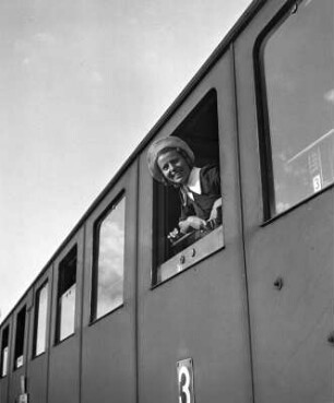 Käthchen im Zug. Mädchen, aus einem Abteilfenster schauend