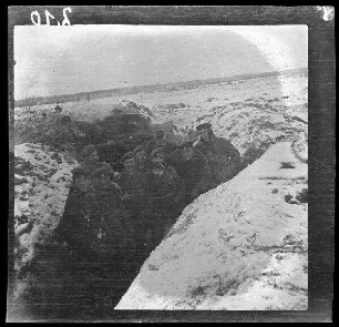 Komaika-Stellung (=Kamaja/Kamoja, Gewässer in Litauen): mehrere Soldaten in einem verschneiten Laufgraben ("Gruppenbild in der Komaika-Stellung")