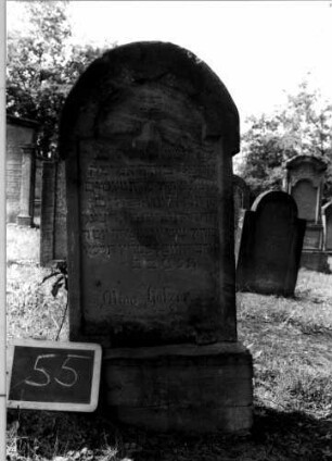 Grabstein 55 (Index: 100107241) Material: Sandstein Zustand: teilweise abgeblättert Maße HxBxT: 113x47x15 cm Beschreibung: Stele, Sockel, ausgezogener Rundbogenabschluß, Schriftfeld mit eingezogenem Rundbogenabschluß: Grabstein 55
