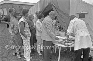 Straßenfest Krögerkoppel: Anwohner bei der Essensausgabe: im Hintergrund Zelt und Gebäude