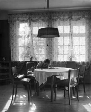 Kinderbilder. Kleines Mädchen, an einem Eßtisch sitzend (in Bayreuth)