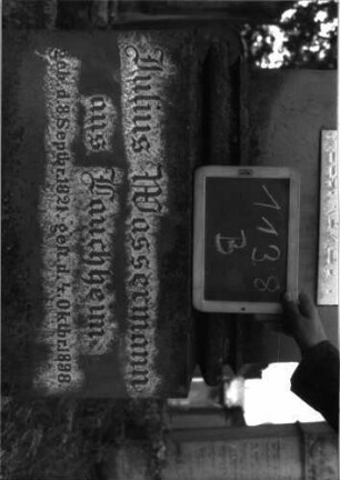 Grabstein 1138 (Index: 100104240) Material: Sandstein, Marmor Zustand: gut erhalten Maße HxBxT: 176x53x22 cm Beschreibung: Stele auf getrepptem Sockel, Giebelaufsatz mit Eckakroterien (Akanthus), eingelassene hochrechteckige Schrifttafel, unterster Sockel felsartig gearbeitet Symbolik: Akanthus: Grabstein 1138B