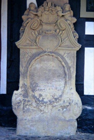barocker Grabstein an der Kirchenmauer