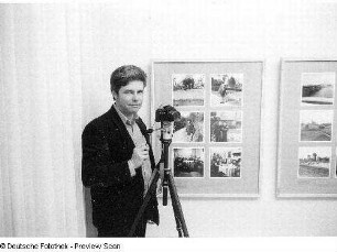 Christian Borchert mit Kamera in seiner Ausstellung anläßlich eines Ausstellungsgespräches, aufgenommen in Neubrandenburg