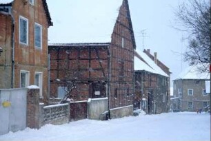 Dorfstraße im Winter mit viel Schnee, Häuser