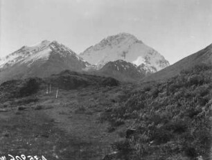 Gipfel : Blick über einen Berghang auf schneebedeckte Gipfel im Tian Shan Hochgebirge