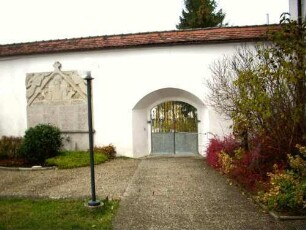 Kirchhof im Westen mit Kirchhofmauer südlich am Langhaus-erhaltener Torbogen der Toranlage (Wehrgang und Kammertor im 18 Jh abgetragen)