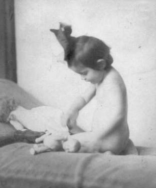 Album mit Porträtserie eines kleinen Mädchens. Sitzender Akt im Profil, mit einer Puppe spielend