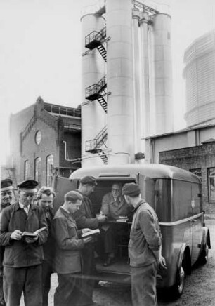 Hamburg. Arbeiter stehen an einem Fahrzeug der Werkbücherei der Hamburger Gaswerke