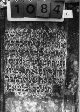 Grabstein 1084 (Index: 99753307) Material: Sandstein Zustand: leicht verwittert Maße HxBxT: 131x104x15 cm Beschreibung: Doppelstele, zwei Schriftfelder eingetieft Symbolik: zwei Muscheln, Blätter: Grabstein 1084C