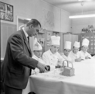 Marburg. Auszubildenden der Hotelfachklasse wird das Einschenken von Flaschenweinen gezeigt