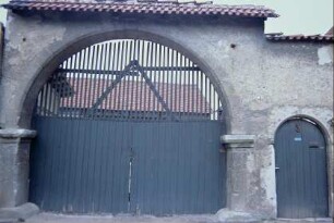 Detail voriges Bild: Hofmauer mit rundbogigem Tor und Personenpforte
