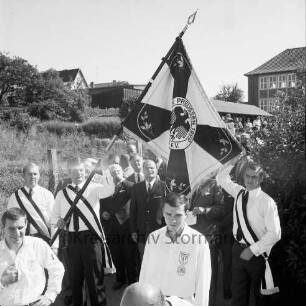 Reinfelder Sportverein SV Preußen von 1909 e.V.: 60-jähriges Jubiläum: Festumzug: Weg hinter Matthias-Claudius-Schule: Fahnenträger mit neuer Vereinsfahne, Vorderseite: dahinter Bürgervorsteher Edgar Keiselt, Bürgermeister Richard Hingst, Stadtverordnete, Vereinsvorsitzender Max Fischer, Vereinsvorstand: hinten Zuschauer, Schulgebäude, 7. September 1969