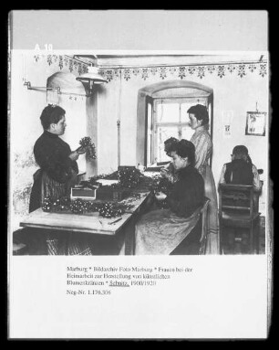 Frauen bei der Heimarbeit zur Herstellung von künstlichen Blumenkränzen