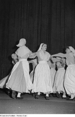 Tanzende Frauen in Tracht auf einer Bühne