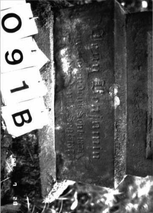 Grabstein 91 (Index: 100101315) Material: Sandstein Zustand: Sockel verwittert Maße HxBxT: 92x47x20 cm Beschreibung: Stele, getreppter Sockel, Rundbogenabschluß Besonderheit: Kindergrab: Grabstein 91B