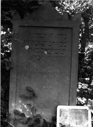 Grabstein 2 (Index: 100101067) Material: Sandstein Zustand: unten leicht abgeblättert Maße HxBxT: 112x55x10 cm Beschreibung: Stele, giebelartiger Abschluß mit Eckakroteren, eingetieftes Schriftfeld rechteckig: Grabstein 2