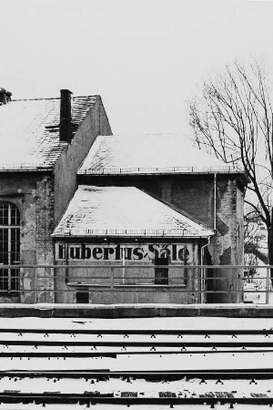 Gebäude mit Aufschrift "Hubertus-Säle" hinter Bahngleisen