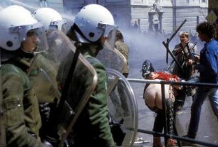 Ein Demonstrant zeigt Polizisten seinen Hintern während der Demonstration gegen das Treffen ehemaliger Mitglieder der Waffen-SS in Nesselwang