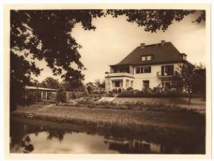 Garten Stier, Potsdam: Ansicht von der Wasserseite (Hafengraben) auf Garten und Haus mit Bootshaus und Geräteschuppen