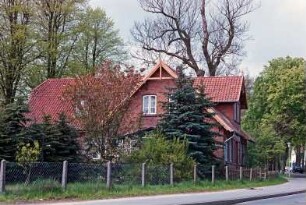 Allee 1: traufständiges Wohnhaus aus Backstein: Giebelseite, nach Erneuerung von Ortgängen und Giebelzier aus Holz: rechts Straßenfront mit Zwerchhaus: links rückwärtiger Querbau: davor Garten, Maschendrahtzaun: 5. Mai 1994
