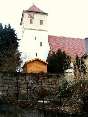 Ansicht von Süden mit Kirche (Kirchturm mit Schlitzscharten) über Kirchhofmauer (Wehrgang mit Steinbrüstung abgetragen)