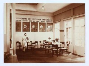 Ausstellungsraum des Reichsverbandes des deutschen Gartenbaues : Dresden. Internationale Hygieneausstellung 1930/1931. Ausstellungsraum des Reichsverbandes des deutschen Gartenbaues. Caféteria mit Informationstafeln