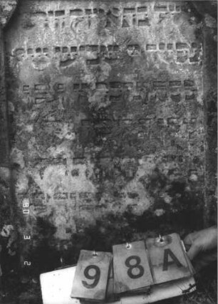 Grabstein 98 (Index: 99608782) Material: Sandstein Zustand: stärker verwittert Maße HxBxT: 91x58x13 cm Beschreibung: Stele mit geschwungenem Doppelbogen, vertiefter Textteil in gleicher Form: Grabstein 98A