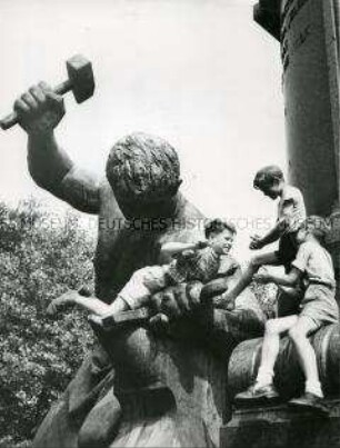 Kinder spielen auf einem Denkmal