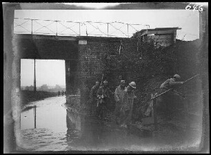 bei Neuville (=Neuville-Saint-Vaast, Dep. Pas-de-Calais, Frankreich): Soldaten (französische Kriegsgefangene?) vor einer überfluteten Unterführung