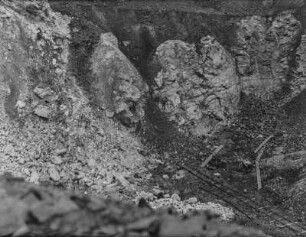 Bergbau : Blick in eine Grube mit zwei Schubkarren vor der Abbauhalde