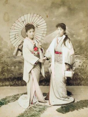 Zwei Frauen in traditioneller Kleidung und Sonnenschirm