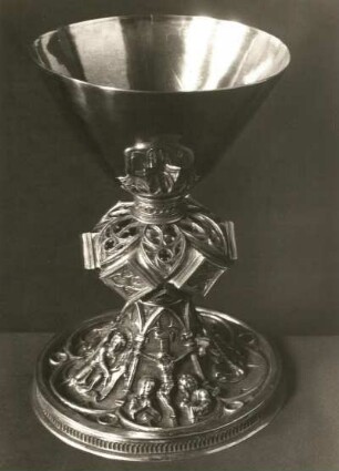 Döbeln, Nikolaikirche. Abendmahlskelch. Silber, vergoldet; Höhe 22 cm, Fußbreite 17 cm. Fußplatte mit fünf Spitzbogen auf Säulen und Kreuzigungsgruppe mit vier Evangelistensymbolen (Höhe je 7 cm). Um 1470