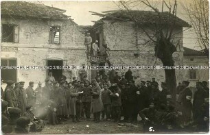 Deutsche Soldaten und Zivilisten bei Aufräumarbeiten in einer zerstörten Ortschaft (auf dem Balkan?)