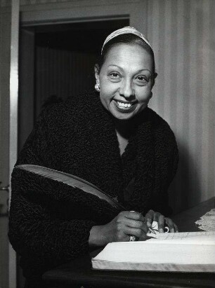 Josephine Baker [trägt sich in ein Gästebuch ein]