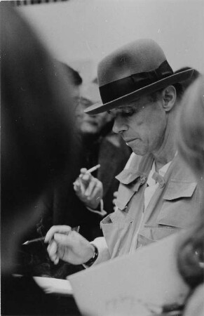 Der Künstler Joseph Beuys beim Signieren