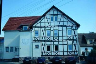 großes Gebäude mit Fachwerk, Spruch an der Wand