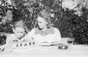 Porträt von Walter Dehmel mit Familie im Garten : Frau Dehmel mit Enkelsohn beim Spielen an einem Tisch