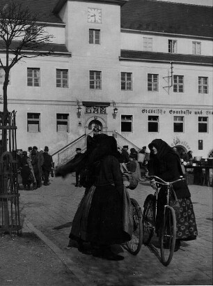 Hoyerswerda (Schlesien). Sorbische Frauen in Trachten auf dem Marktplatz vor dem Rathaus der Stadt. Sie unterhalten sich