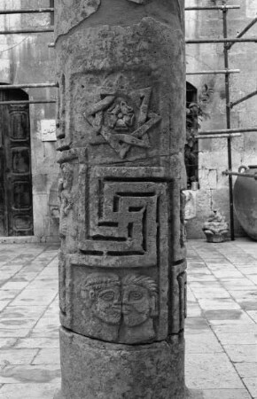 Säule mit Doppelmäander und Gesichtern