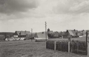 Zinnwald-Georgenfeld. Ortsteilansicht mit Gasthof "Grenzsteinhof" und Kirche. Blick von Westen