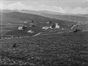Dorf im Tal : Ein Dorf von Feldern umgeben in einem Tal. Im Hintergrund hohe Berge