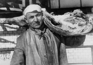 Der Schlachter ist froh. Die Zeiten werden wieder normal. Jeder kann Fleisch kaufen. Er trägt eine Schweinehälfte auf der Schulter