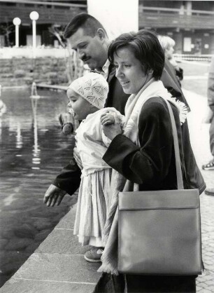 Junge Familie an einem Brunnen