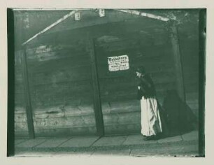 Straßenszene, Frau an einer Holzwand vorübergehend - "Bethabara [...]"