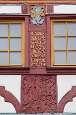 Spruch und geschnitzte Ornamentik an der Hausfassade