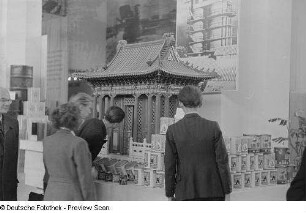 Besucher vor einem Messestand mit chinesischen Lackfarben