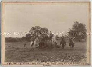 Offiziere der Schutztruppe für Deutsch-Südwestafrika und eine Frau auf Pferden vora einem Zeltlager