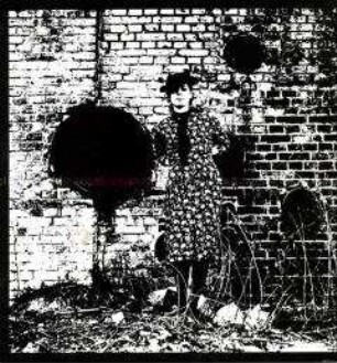 Verfremdete Aufnahme einer jungen Frau, die an einer Mauer steht