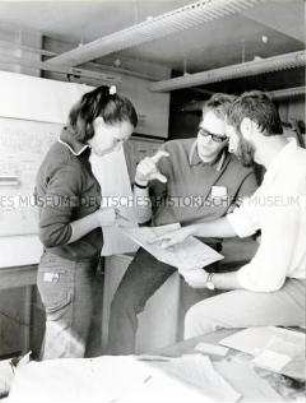 Gruppe "Junger Neuerer" im VEB Elektro-Apparate-Werke "Friedrich Ebert" (EAW) in Berlin-Treptow studieren Maschinenbaupläne